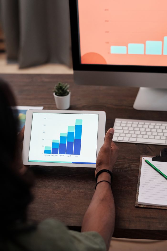 Home A person reviews statistical graphs on a tablet, showcasing data analysis and technology.
