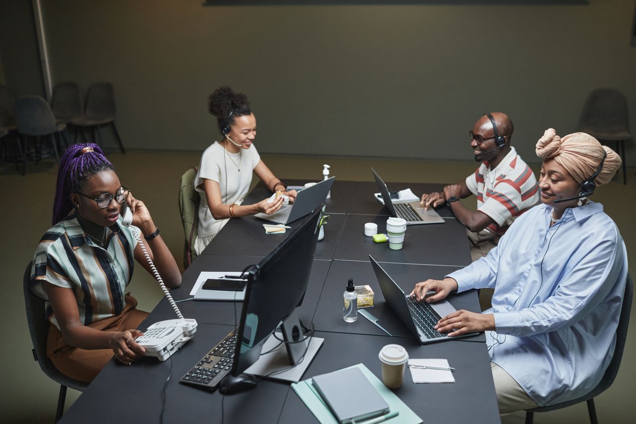 Home Diverse call center team working collaboratively with technology and headsets in a modern office setting.