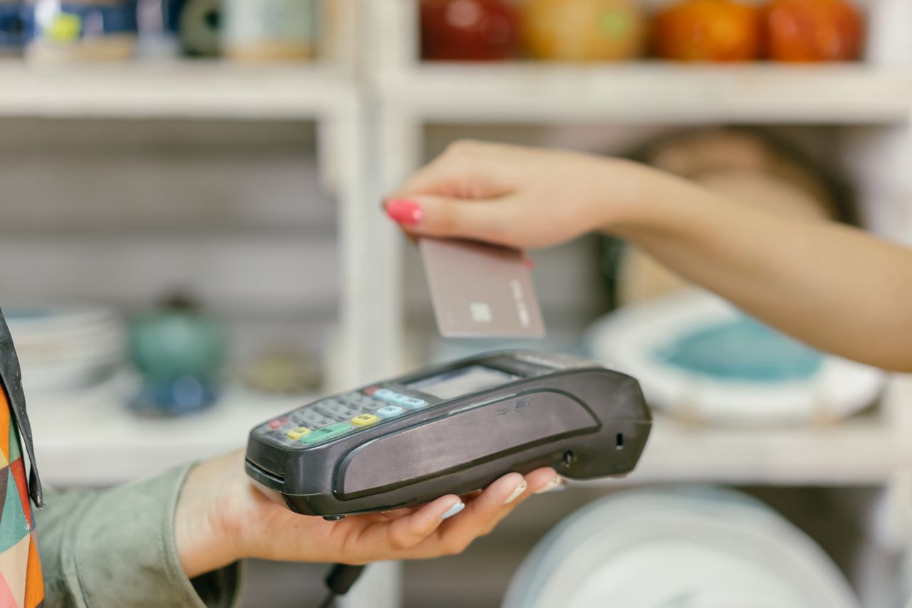 Home A hand using a credit card for payment at a point of sale terminal, close-up view.